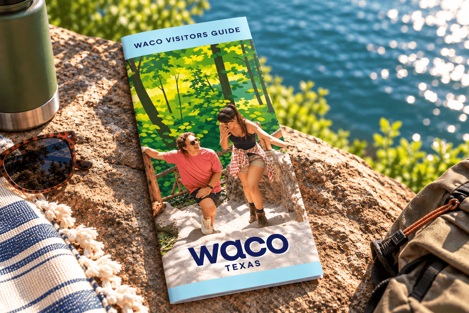 A Waco visitors guide brochure rests on a sunny rock near a lake in McLennan County, Texas.