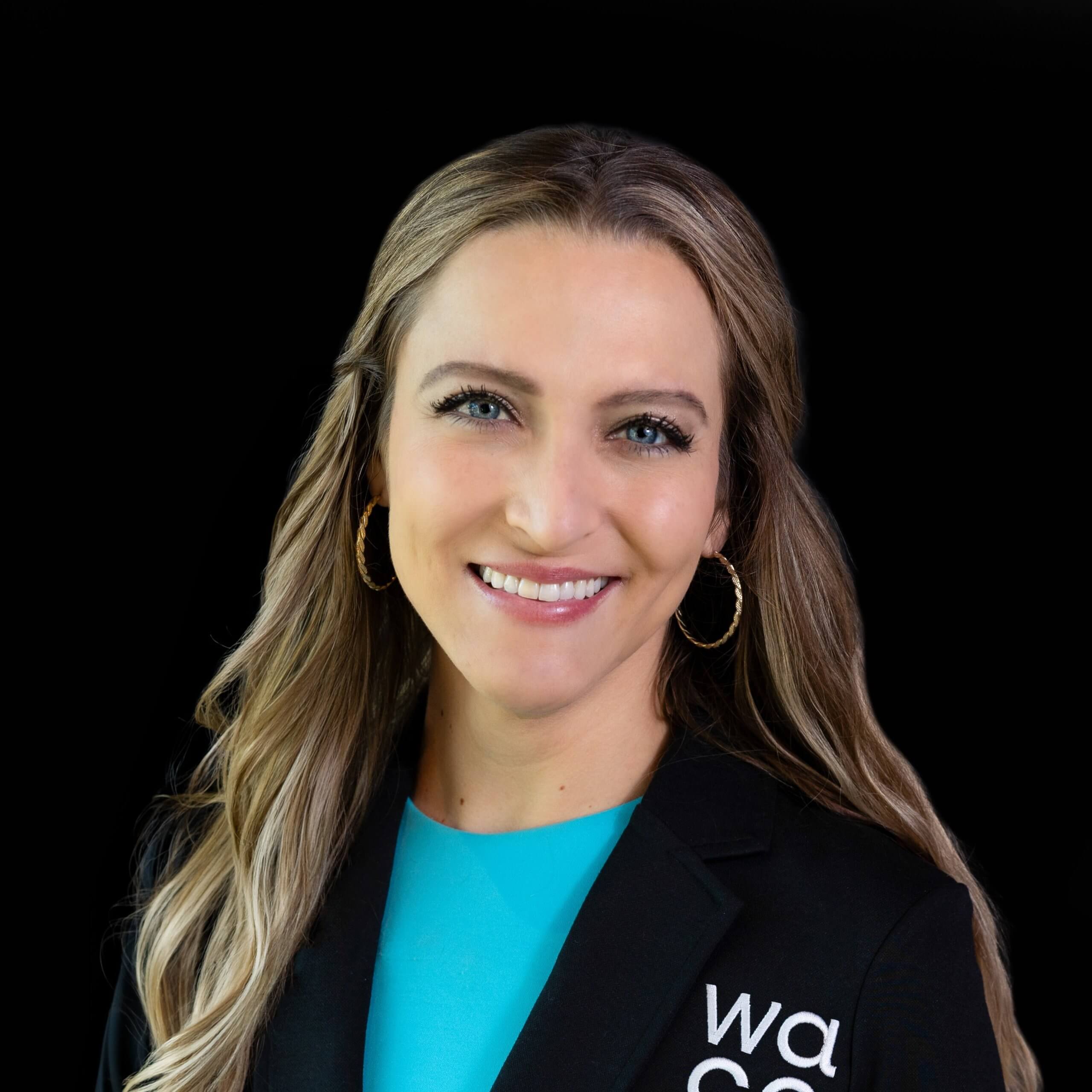 A smiling woman with long blonde hair wearing a black blazer and blue top in McLennan County, Texas.