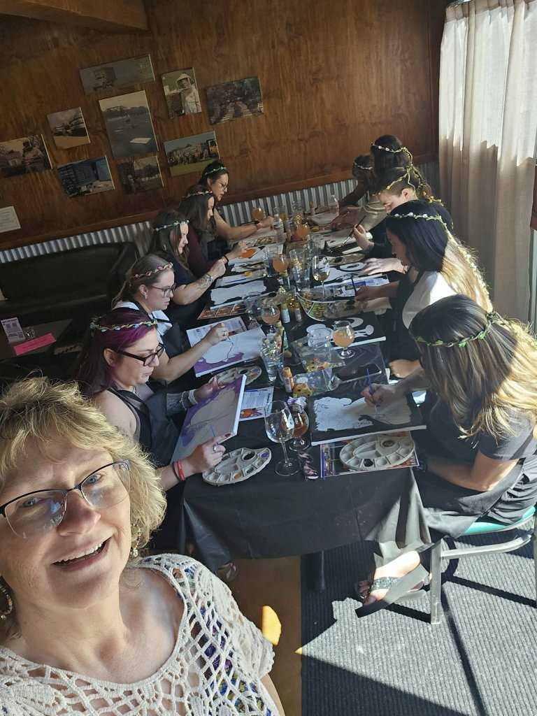 A group of women wearing flower crowns participating in a painting class together in McLennan County, Texas.