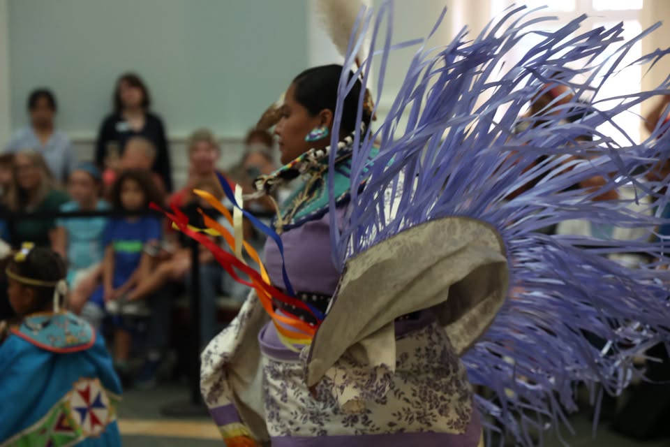 A person in traditional Native American regalia performing a dance with flowing ribbons in McLennan County, Texas.